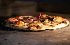 Wood-fired pizza served at Mucobega Resort restaurant in Saranda